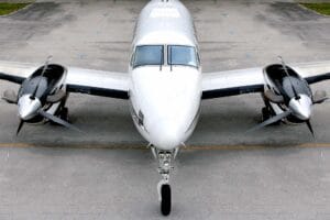 White business aircraft parked on the ramp with nosewheel in the front centered.